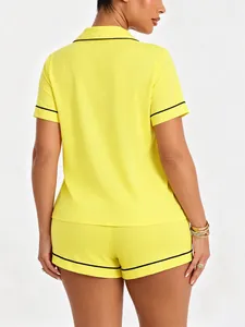 Back view of women's bright yellow short sleeve pajama set featuring elegant black piping
