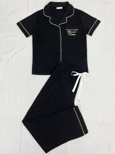 Vue détaillée d'un ensemble de pyjama noir avec broderie 'Blessed Mama' et liseré blanc
