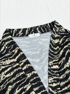 Nahaufnahme eines Tiger-Pyjama-Bademantels für Damen mit S-Größenetikett-Detail.