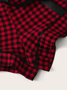 Detailed macro shot of red and black buffalo plaid pajama shorts with soft satin trim.
