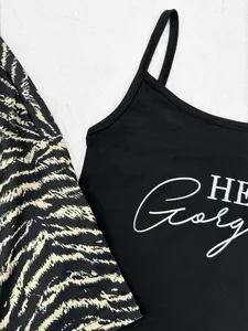 Detailaufnahme eines schwarzen Tops mit Aufdruck und einer Robe mit Zebramuster