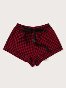 Close-up view of red and black buffalo plaid pajama shorts with a stylish satin bow