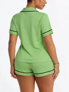 Back view of women's lime green short sleeve pajama set featuring black contrast piping