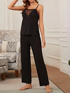 Close-up detail of women's black camisole pajama set featuring mesh neckline and lace trim