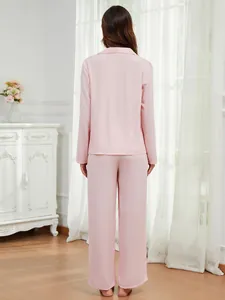 Rückansicht eines zartrosa langärmeligen Damen-Pyjama-Sets in wohnlicher Umgebung.