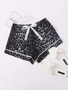 Detailed macro view of leopard print pajama shorts featuring a white bow and trim