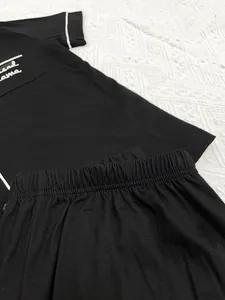 Gros plan d'un ensemble pyjama noir avec broderie "Blessed Mama" et taille élastique.