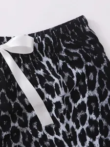 Close-up detail of women's leopard print pajama shorts with a white satin bow