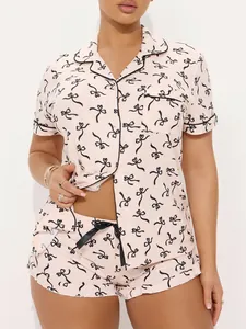 Close-up detail of women's pink pajama set with black bow print and contrast piping.
