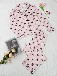 Elegant pink long-sleeved pajama set featuring black bow prints and a lapel collar design