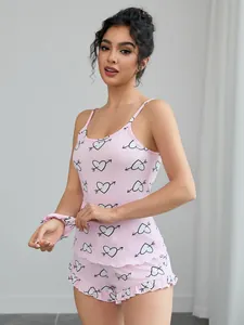 Detailed view of pink heart and arrow print camisole and ruffled shorts pajama set