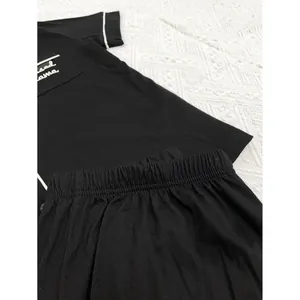 Détail d'un ensemble de pyjama noir pour femmes avec broderies et passepoils blancs
