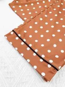 Detail macro view of polka dot pajama pants with elegant black contrast piping trim