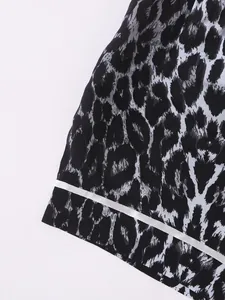 Macro detail of leopard print pajama shorts featuring white contrast piping on the hem