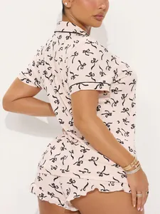 Side view detail of women's pink pajama set with stylish black bow print and contrast piping