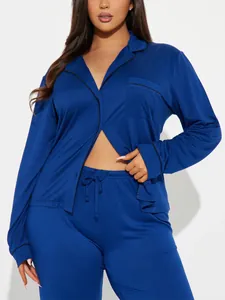 Vue détaillée d'un pyjama en satin bleu avec liseré noir et une poche poitrine.