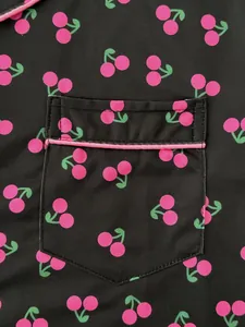 Vue macro rapprochée du détail de la poche à motif cerise rose sur pyjama noir femme