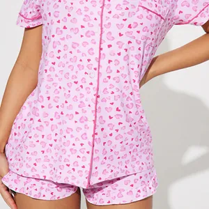 Lovely pink heart print women's pajama set featuring short sleeves and ruffled shorts