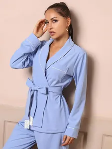Detailed view of women's light blue long-sleeve pajama set with white piping and tie-waist
