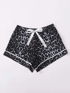 Detailed view of women's black and white leopard print pajama shorts with a white bow