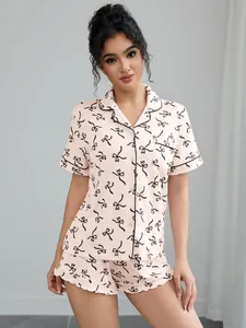 Women's light pink two-piece pajama set with black bow print and contrast piping trim