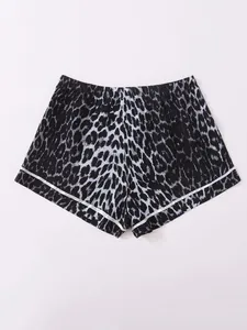 Close-up of leopard print women's pajama shorts with elastic waist and white piping detail