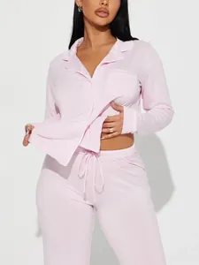 Vue détaillée d'un haut de pyjama rose à manches longues avec des passepoils blancs.