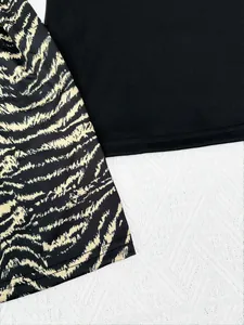 Detailaufnahme vom Saum aus schwarzem und Tiger-Print-Stoff für Damen-Pyjamas