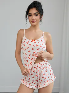 Modèle portant un ensemble de pyjama blanc avec caraco à cerises et short à volants