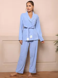 Full view of light blue robe-style pajama set with belted waist and tassel details