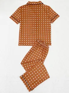 Detail of polka dot pajama set featuring short sleeve shirt and long pants in rust brown