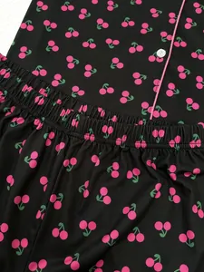 Détail d'un pyjama noir pour femme avec motif de cerises roses et taille élastique