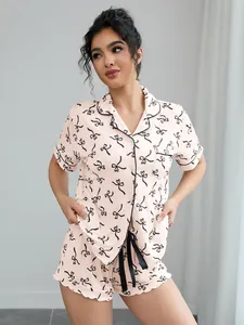 Detail view of pink women's summer pajama set showing bow print and black piping.