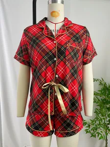 Détail d'un ensemble pyjama femme à carreaux rouges avec ruban doré sur mannequin