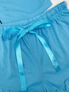 Gros plan d'un short de pyjama bleu clair avec un nœud de taille en ruban satin