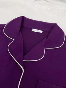 Détail d'un haut de pyjama violet pour femme avec liseré blanc et étiquette de taille S