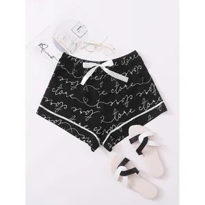 Stylish women's summer pajama shorts with black script print and elegant white bow.
