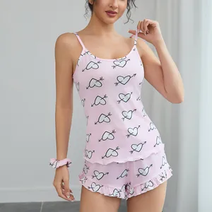Comfortable pink two-piece pajama set with heart print camisole and ruffle shorts.