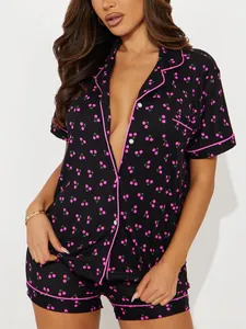 Détail de l'ensemble de pyjama noir à manches courtes avec motifs cerises roses et liseré