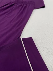 Gros plan d'un pantalon de pyjama violet avec passepoil blanc et texture douce