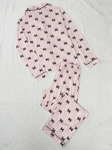 Detailed view of pink women's pajama set featuring a cute black bow print and lapel collar