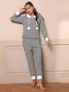 Full-length view of a model wearing a stylish black and white striped hooded pajama set