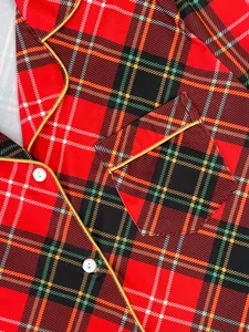 Gros plan détaillé d'un haut de pyjama à carreaux rouges avec liseré jaune et boutons