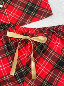 Détail du short de pyjama à carreaux rouges avec un nœud en satin doré à la taille
