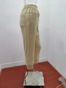 Side profile view of women's beige cotton linen cropped pants with drawstring waist