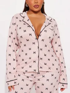 Detailed view of women's pink pajama set featuring black bow patterns and lapel collar design
