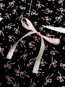 Vue détaillée d'un short de pyjama noir avec imprimé nœud rose et cordon en satin