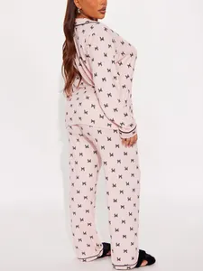 Back view of a pink long-sleeved pajama set featuring an all-over black bow print