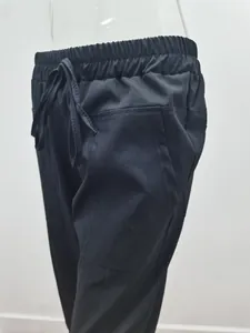 Detail of black cotton linen pants showing elastic drawstring waist and side pocket design
