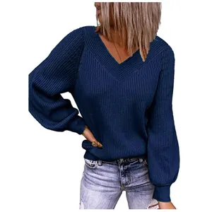 Close-up detail of navy blue ribbed knit texture and V-neckline on a loose pullover sweater.